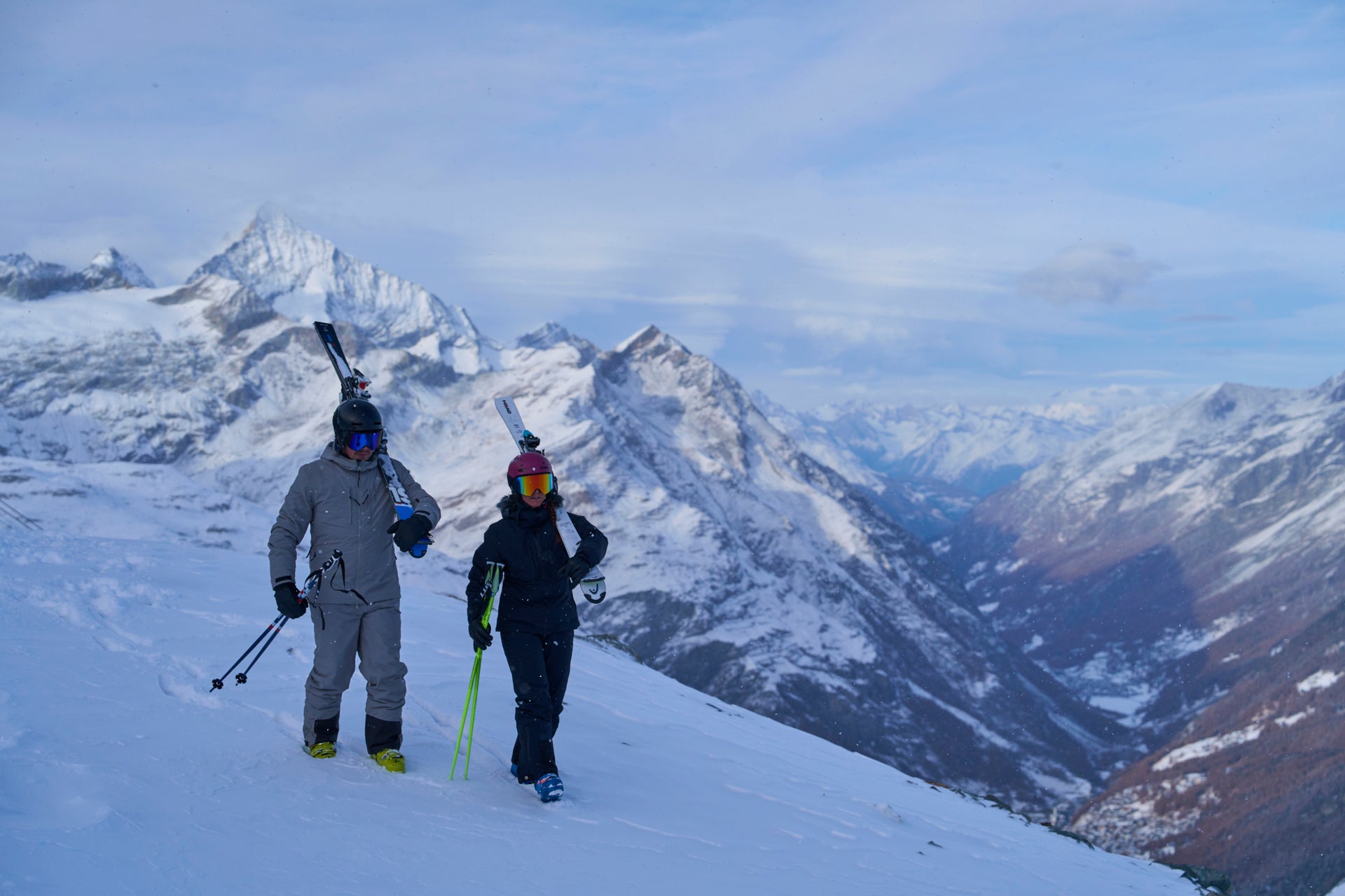 Skiers with Untrakt gear on a snowy mountain with a scenic backdrop